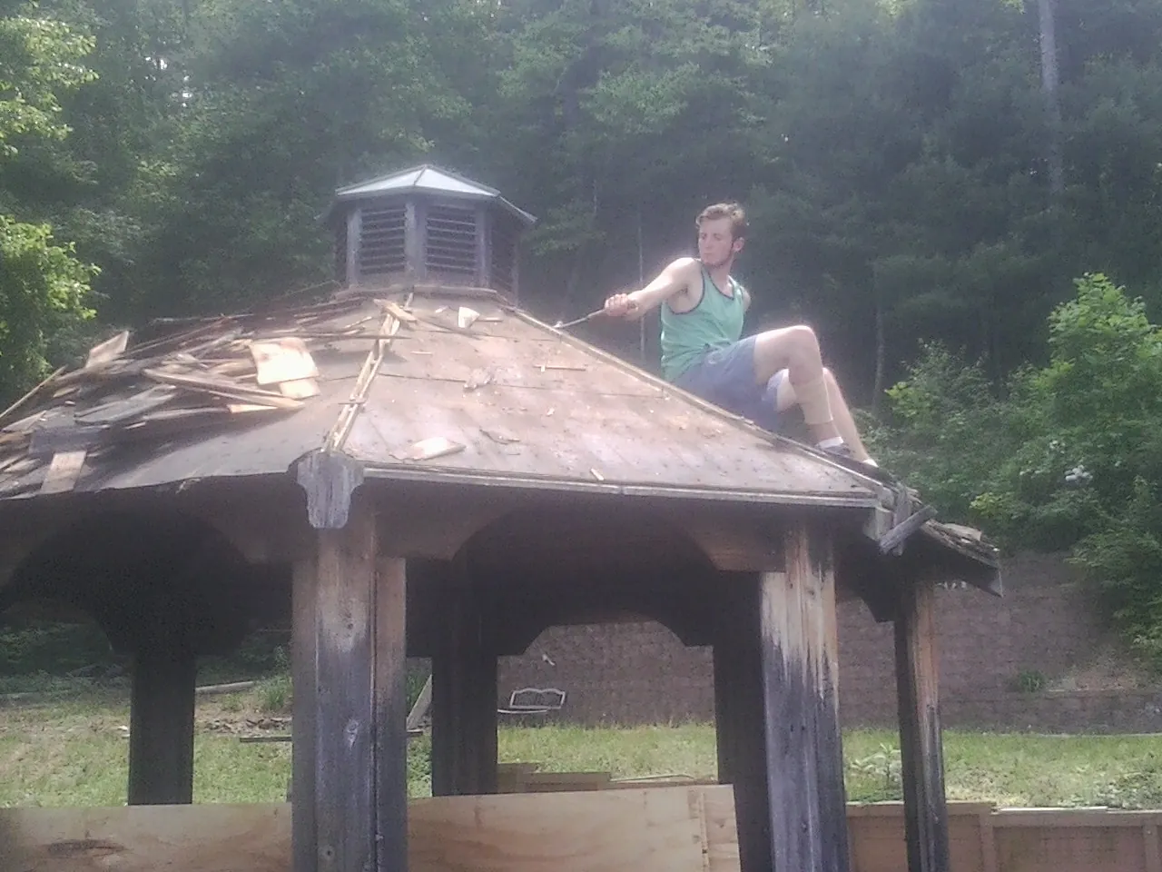 Tearing the old roof off a wooden gazebo before new shakes in Dunbar