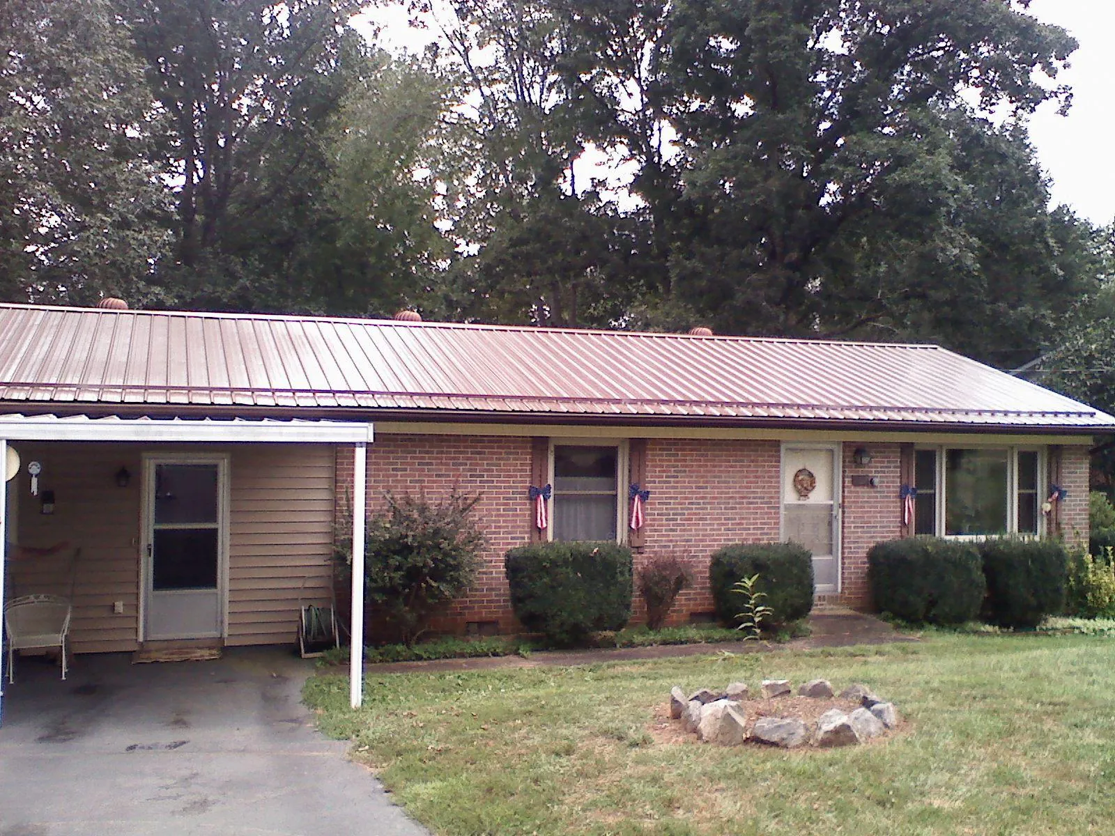 Bronze metal roof and carport on a brick ranch home — Roof Repair work by our crew in Dunbar